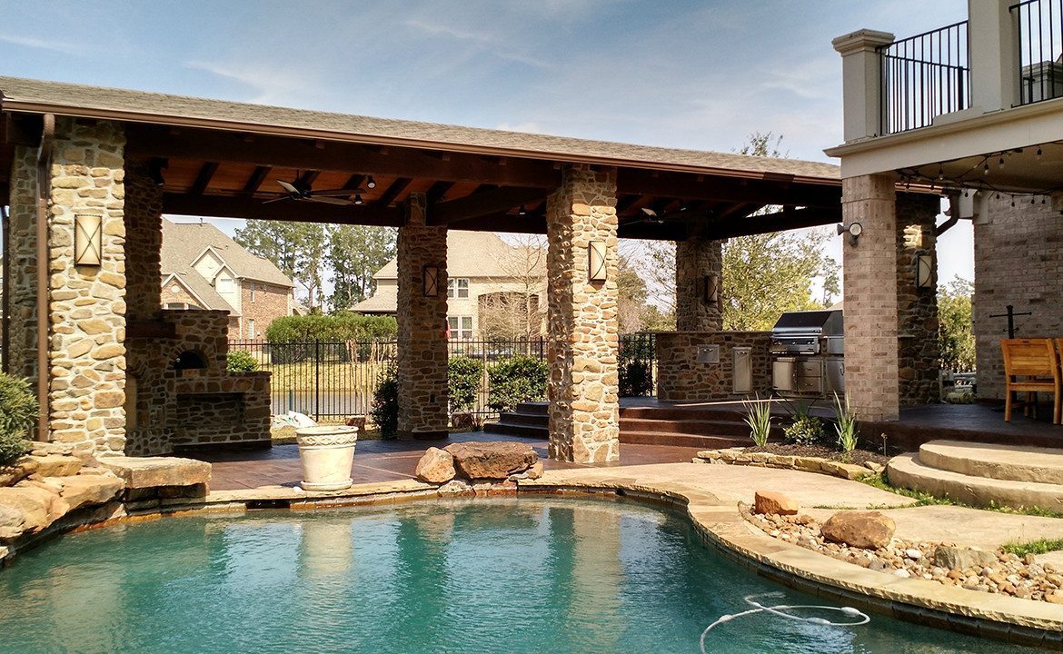 an above ground pool sets on a concrete pad in the backyard on a sunny summer day.